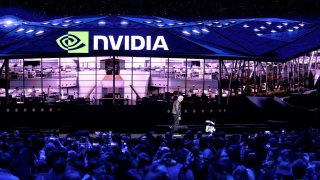 Nvidia CEO Jensen Huang talks to a robot during a keynote session at the SAP Center in San Jose, California, on March 18, 2025.