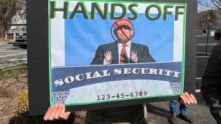 A person holds a sign during a protest against cuts made by U.S. President Donald Trump’s administration to the Social Security Administration, in White Plains, New York, U.S., March 22, 2025. 