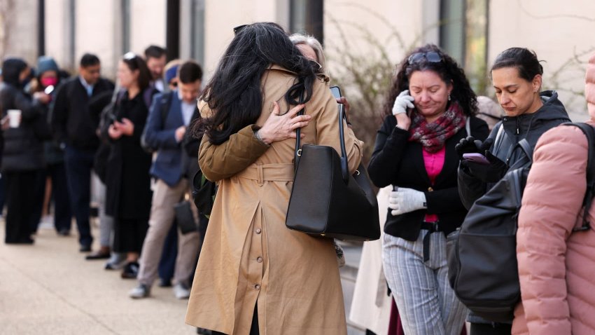 Employees of the Department of Health and Human Services (HHS) hug each other as they queue outside the Mary E. Switzer Memorial Building, after it was reported that the Trump administration fired staff at the Centers for Disease Control and Prevention and at the Food and Drug Administration, as it embarked on its plan to cut 10,000 jobs at HHS, in Washington, D.C., U.S., April 1, 2025.