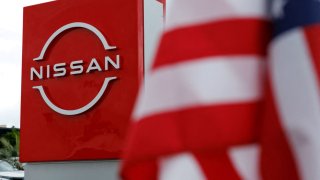 FILE PHOTO: The American flag flutters at a Nissan automobile dealership in Irvine, California, U.S., March 27, 2025. 