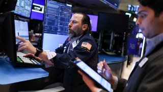 Traders work on the floor of the New York Stock Exchange at the opening bell on April 10, 2025.