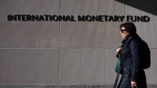 A woman walks past the International Monetary Fund ahead of the International Monetary Fund/World Bank Spring Meetings in Washington, DC, on April 17, 2025.