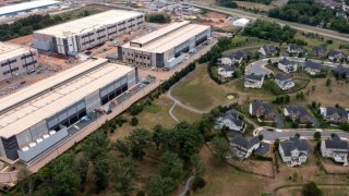 In an aerial view, an Amazon Web Services data center is shown situated near single-family homes on July 17, 2024 in Stone Ridge, Virginia.
