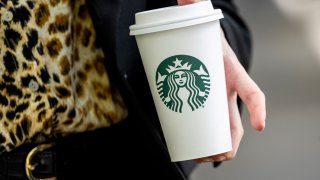 A pedestrian holds a Starbucks cup in Sacramento, California, on April 28, 2025.