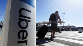 A passenger walks near Uber signage after arriving at Los Angeles International Airport in Los Angeles, California, on July 10, 2022.