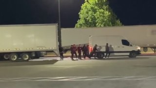 A group of suspects is shown stealing cargo from a truck and loading it into their vehicle last year in California.