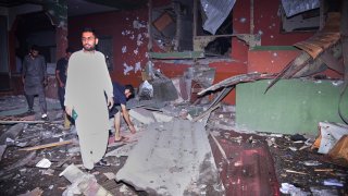 Local residents examine a building damaged from a suspected Indian missile attack near Muzaffarabad, the capital of Pakistan controlled Kashmir, in Wednesday, May 7, 2025.