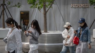 Shoppers pass an Hermes store, operated by Hermes International SCA, in Beijing, China, on Thursday, May 1, 2025.