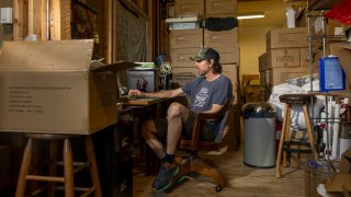 Stephen Kitto, owner of Liquid Hardware, works at his desk on May 8, 2025 in Victor, Idaho. Kitto’s business selling insulated flasks with rare-earth magnetic lids depends on importing his product from a manufacturer in China.