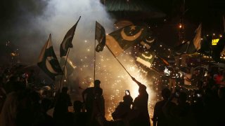 Pakistanis wave the national flag as they celebrate after the ceasefire between Pakistan and India, in Hyderabad, Sindh province, on May 10, 2025. Pakistan and India agreed on May 10, 2025, to a full and immediate ceasefire after days of deadly jet fighter, missile, drone and artillery attacks.