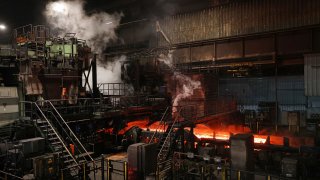 Steel glowing red travels through the rolling mill at the Thyssenkrupp steel plant on April 9, 2025 in Duisburg, Germany.