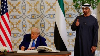 U.S. President Donald Trump signs a guest book next to United Arab Emirates President Sheikh Mohamed bin Zayed Al Nahyan, at Qasr Al Watan, in Abu Dhabi, United Arab Emirates, May 15, 2025.