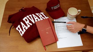 Yu-Hsuan Lin, 27, lays out a Harvard hat, mug, hoodie and her admission letter to Harvard University on a table in Taipei, Taiwan May 24, 2025.
