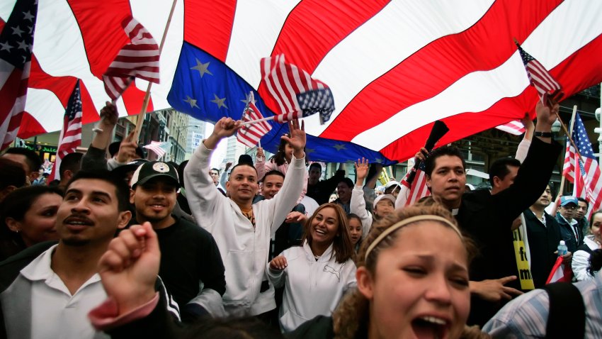 FILE – Participants in an immigration rights rally walk under a giant American flag during a march through downtown Chicago, May 1, 2006.