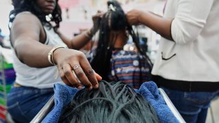 A braider at Eve's African Braiding