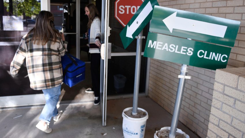 FILE – Health department staff members enter the Andrews County Health Department measles clinic carrying doses of the measles, mumps and rubella vaccine, Tuesday, April 8, 2025, in Andrews, Texas.