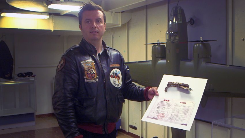 USS Hornet Museum volunteer George Retelas holds an original piece of wreckage from the Doolittle Raid.