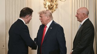 US President Donald Trump (C) shakes hands with Dell Technologies CEO Michael Dell (L) as Goldman Sachs CEO David Solomon (R) looks on as Trump arrives for an “Invest America” roundtable discussion in the State Dining Room of the White House in Washington, DC on June 9, 2025.