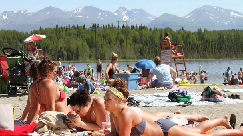 People sunbathe at Goose Lake in Anchorage, Alaska