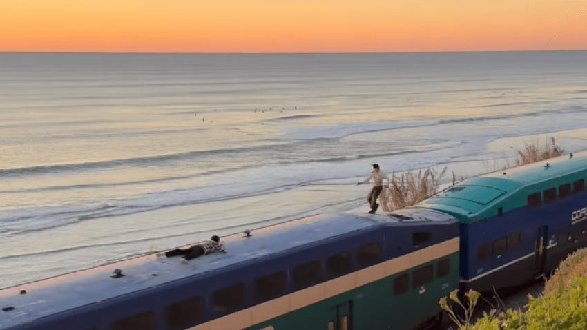 The men were spotted surfing atop the Coaster train on Friday near Del Mar.
