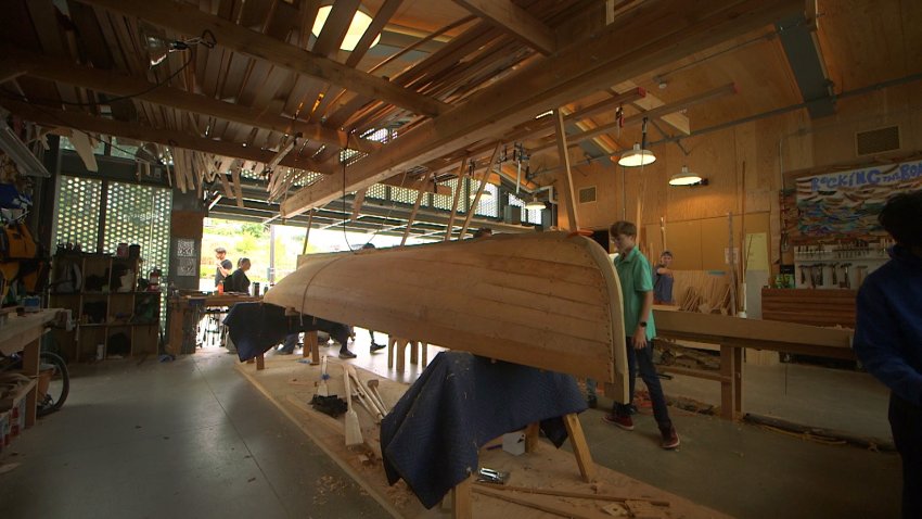Students in the Rocking the Boat program help build a boat.