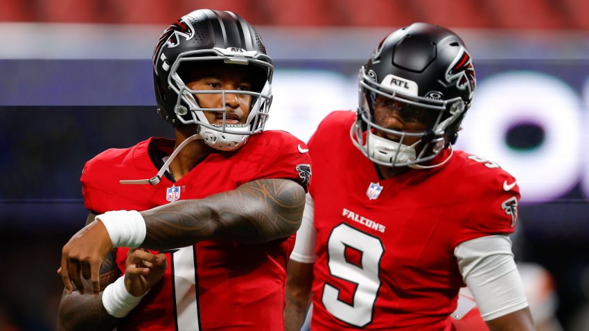 Tua Tagovailoa of the Atlanta Falcons warms up alongside Michael Penix Jr.